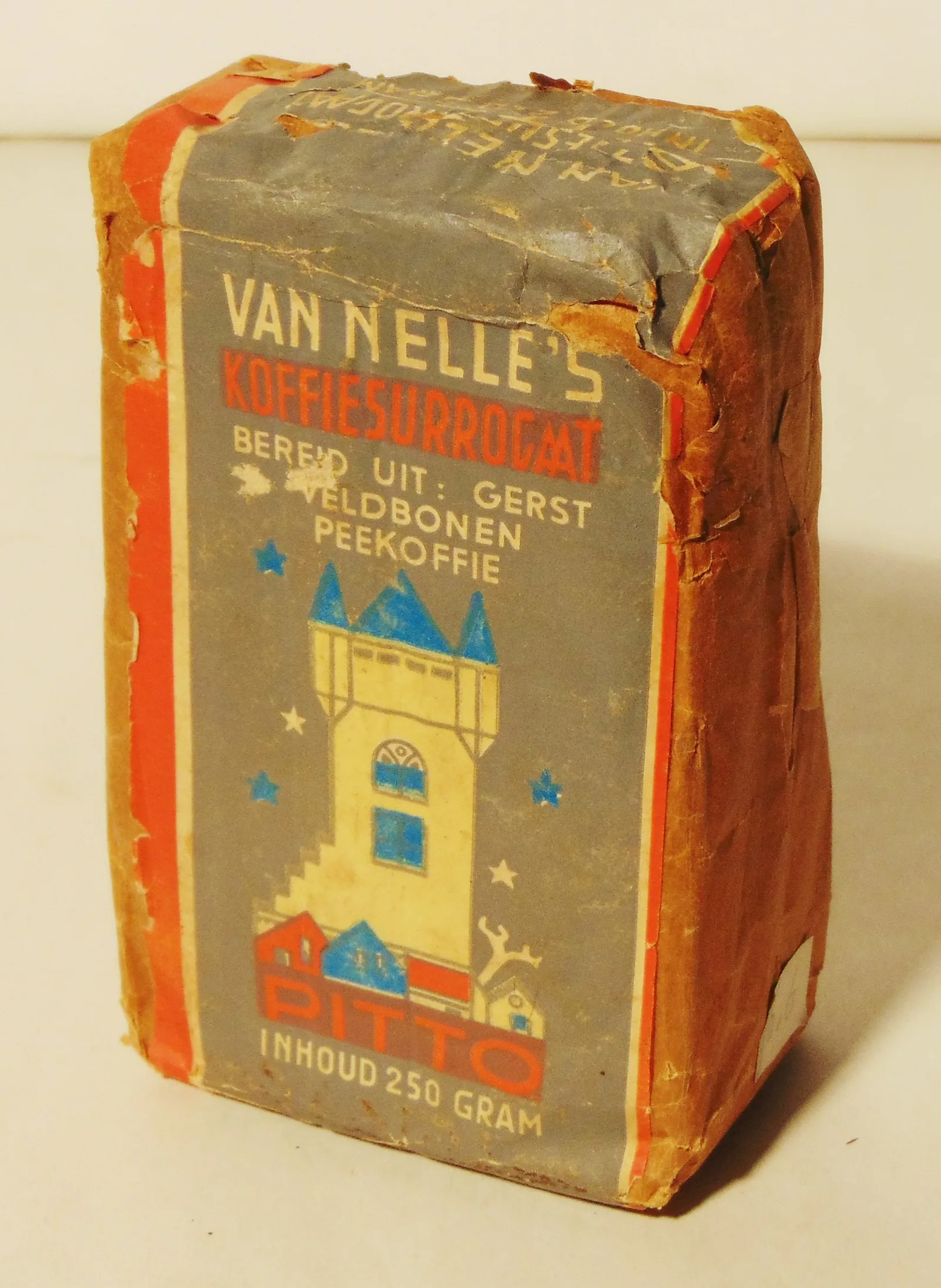 Photographie d'un paquet rectangulaire enveloppé de papier, orné d'un dessin naïf de maison, portant le nom de Van Nelle et l'indication que ce succédané de café est préparé à partir d'orge, de féveroles et de chicorée.