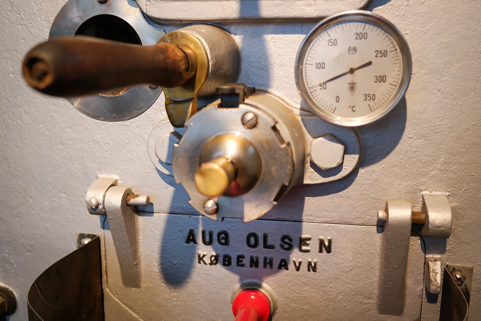 Détail d'un torréfacteur Aug Olsen de Copenhague : levier de bois, robinetterie de laiton et cadran de température gradué jusqu'à 350 degrés.