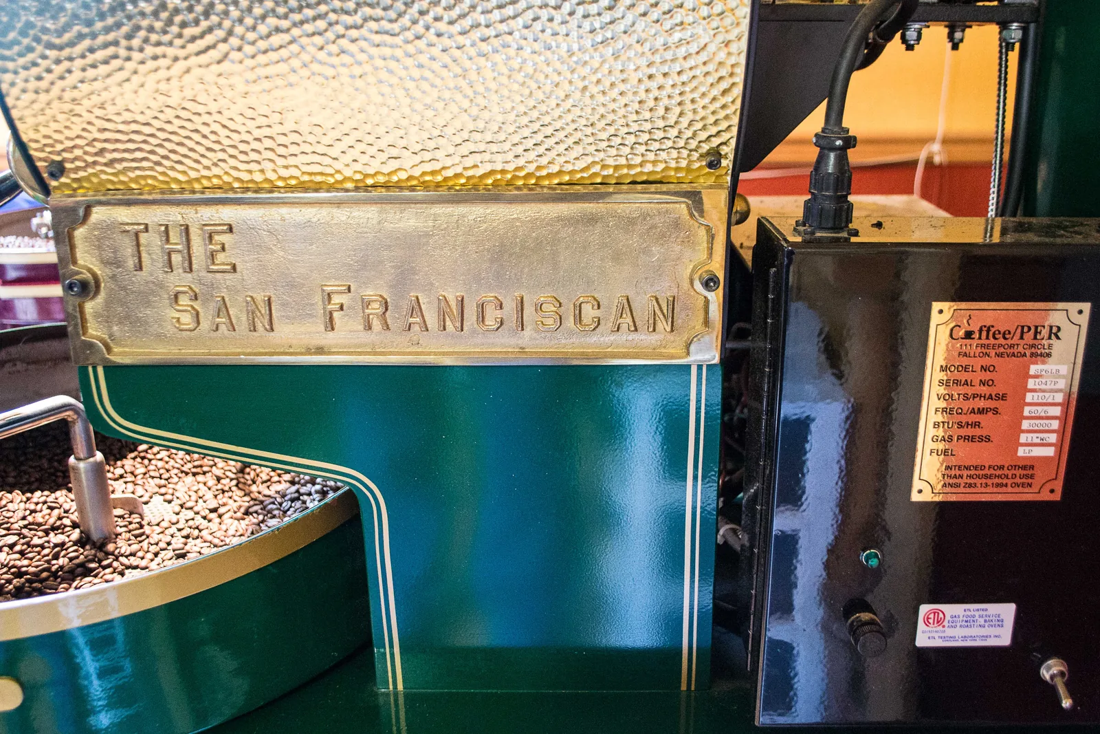 La plaque en laiton « THE SAN FRANCISCAN » est visible sur le flanc d'un torréfacteur modèle SF6, à côté de sa plaque signalétique technique