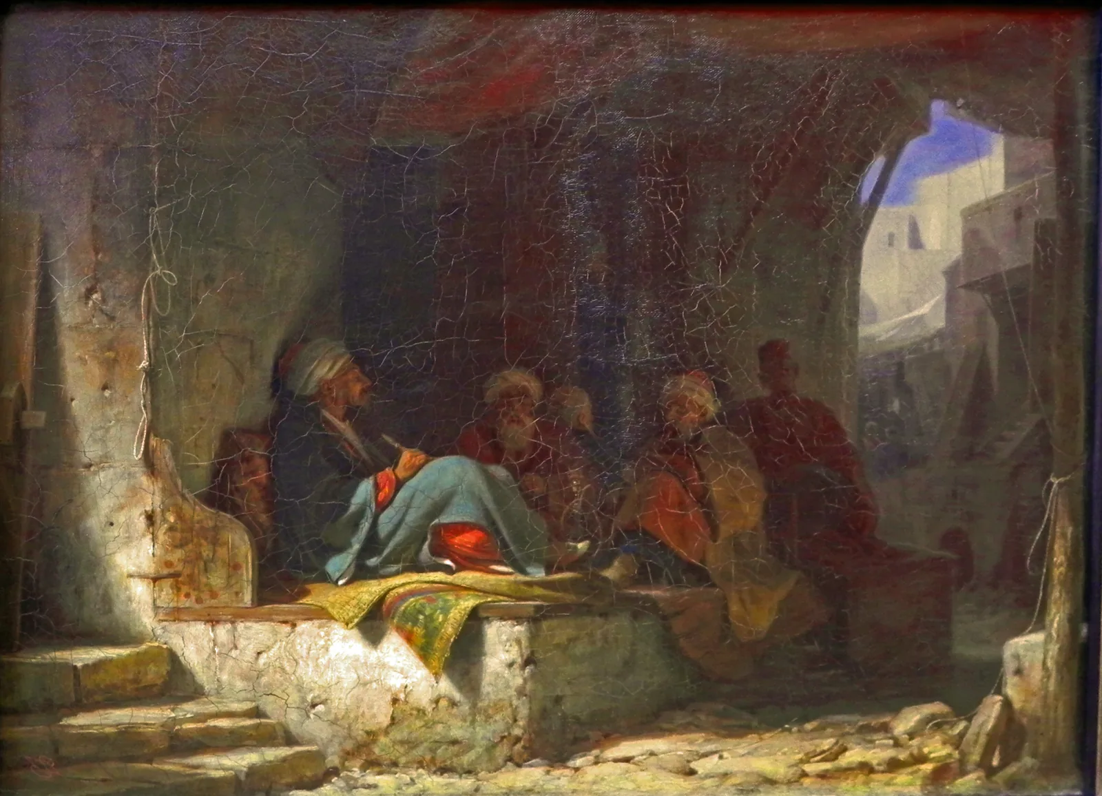 Petite peinture sombre montrant un groupe d'hommes en turban assis à même le sol et sur des estrades, dans une salle voûtée ouverte par une porte lumineuse, pipes longues et tasses à portée de main.