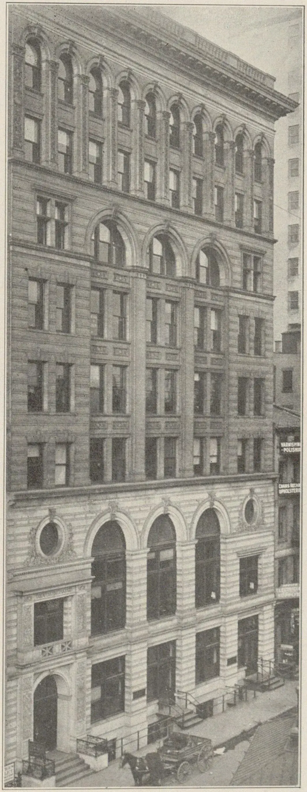 Façade d'un immeuble de bureaux de plusieurs étages, vue depuis la rue en contre-plongée.