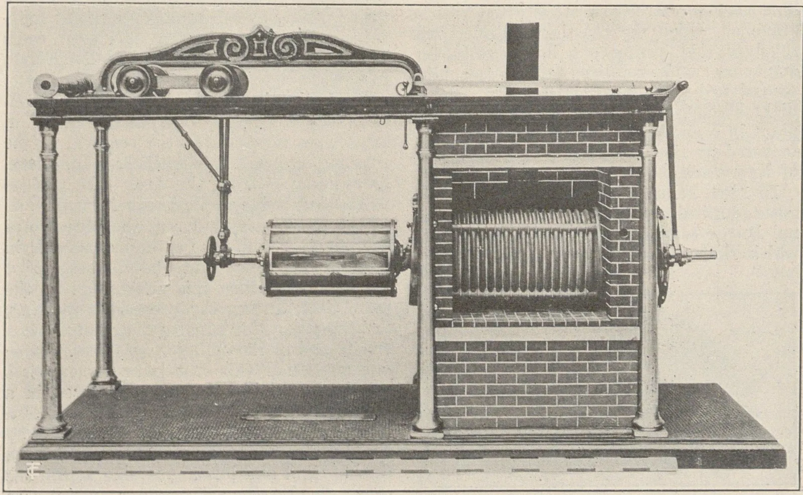 Gravure d'un torréfacteur à cylindre monté devant un massif de brique, avec sa transmission à poulies.