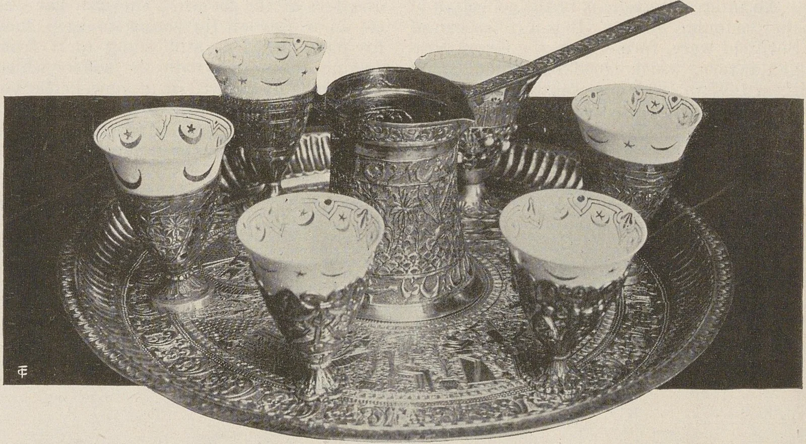 Grand plateau ciselé portant une cafetière centrale entourée de petites tasses posées dans leurs coquetiers.