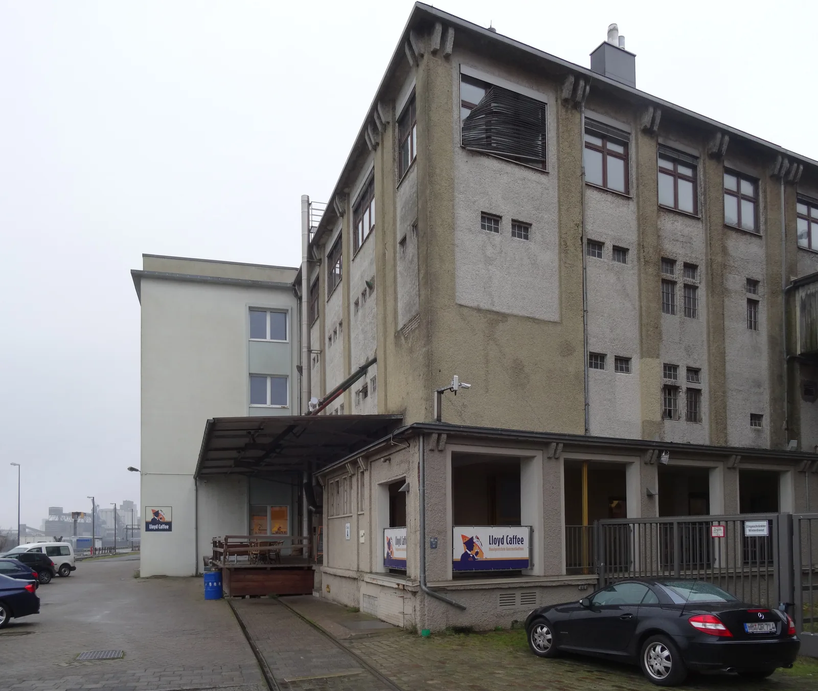 Photographie en couleurs de la façade de brique de l'ancienne usine Kaffee HAG de Brême, longue halle industrielle à travées régulières où la décaféination industrielle a été mise au point, aujourd'hui occupée par une torréfaction.